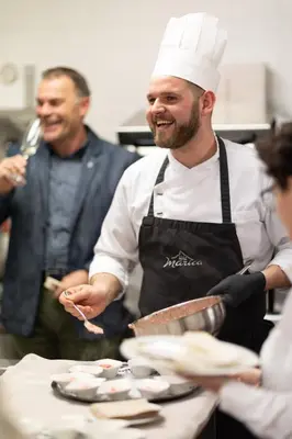 a man standing in a kitchen preparing food at Hotel Marica in Eggen