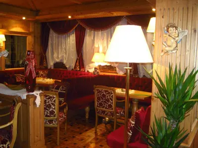 a living room with a couch and a table and a lamp at Hotel Letizia in San Martino di Castrozza