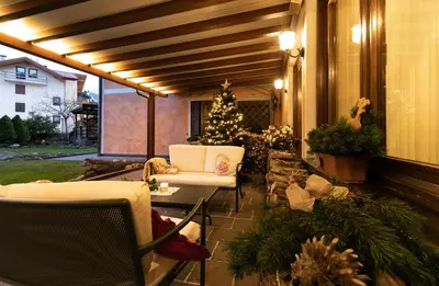 a screened in porch with a christmas tree and chairs at Albergo Conca Verde in Fiera di Primiero