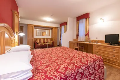 a hotel room with a bed and a television at Albergo Conca Verde in Fiera di Primiero