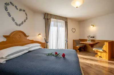 a bedroom with a bed with flowers on it at Albergo Conca Verde in Fiera di Primiero