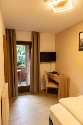 a hotel room with a desk and a bed at Hotel Marlingerhof in Marlengo