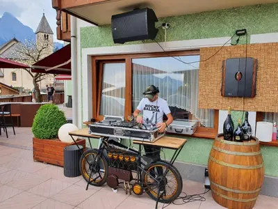 a man standing behind a grill with a bike at B&B La Montanara in San Martino di Castrozza