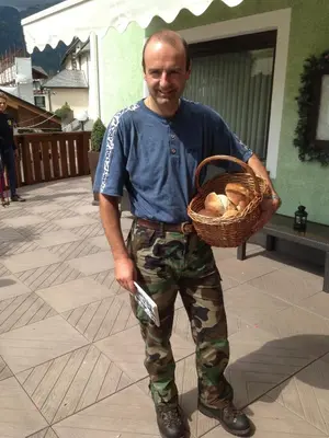 a man is holding a basket of onions at B&B La Montanara in San Martino di Castrozza