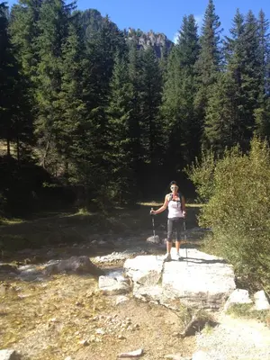 a woman is standing on a path in a river at B&B La Montanara in San Martino di Castrozza