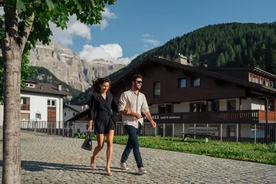 a man and a woman walking down a street at Residence Antares in Selva di Val Gardena