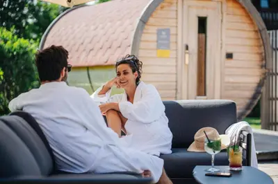 a man and a woman sitting on a couch at Residence Antares in Selva di Val Gardena