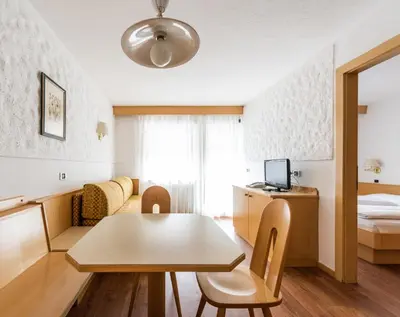 a hotel room with a table and a bed at Residence Antares in Selva di Val Gardena