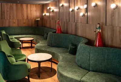a waiting room with green couches and red decorations at Residence Antares in Selva di Val Gardena