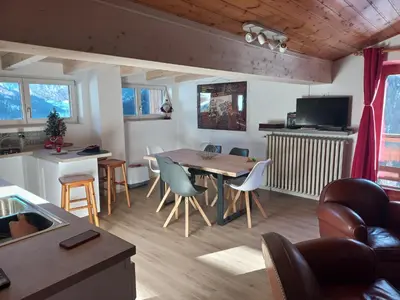 a living room with a wooden table and chairs at Chalet Relax in Pozza di Fassa