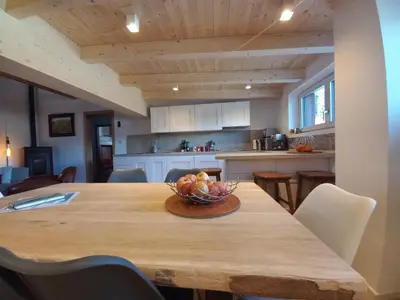 a kitchen with a wooden table with a bowl of fruit on it at Chalet Relax in Pozza di Fassa