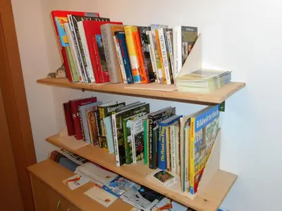 a book shelf filled with lots of books at Agriturismo Ferienhof Gschloier - Adults Only in Laion