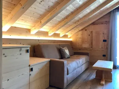 a couch in a room with a wooden ceiling at Apartments Chalet Maria in Badia