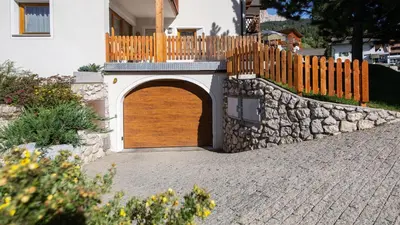 a wooden gate in a stone wall next to a house at Apartments Chalet Maria in Badia