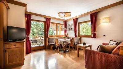 a living room with a table and a tv at Apartments Chalet Maria in Badia