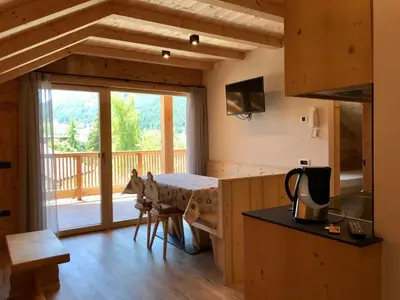 a kitchen with a counter and a table in a room at Apartments Chalet Maria in Badia