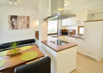 a kitchen with a wooden table and a counter top at Appartment Silvia in St Andrä bei Brixen in Bressanone
