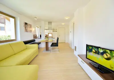 a living room with a yellow couch and a flat screen tv at Appartment Silvia in St Andrä bei Brixen in Bressanone