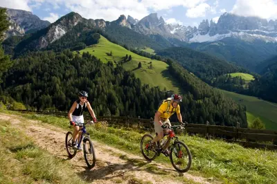 two people riding bikes on a mountain trail at Good Life Hotel Zirm in Obereggen