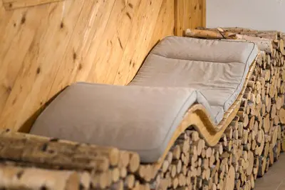 a bed made out of wooden logs with at FORESTO holiday apartments in Tesero