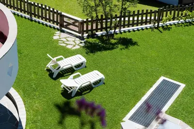 an overhead view of two white lawn chairs and a table at FORESTO holiday apartments in Tesero