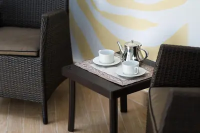 a table with two cups and a tea kettle on it at FORESTO holiday apartments in Tesero