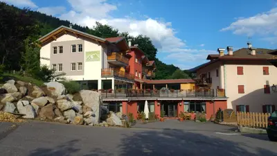 a group of buildings on the side of a mountain at Alpen Garten Hotel Margherita in Rumo