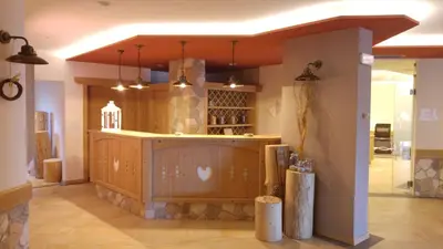a large room with a bar in a building at Alpen Garten Hotel Margherita in Rumo