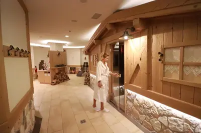 a woman standing in a room in a kitchen at Alpen Garten Hotel Margherita in Rumo