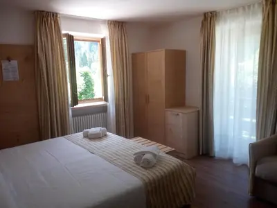 a bedroom with a bed with two towels on it at Hotel Stella Alpina in Falcade