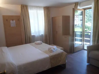 a hotel room with a bed with towels on it at Hotel Stella Alpina in Falcade