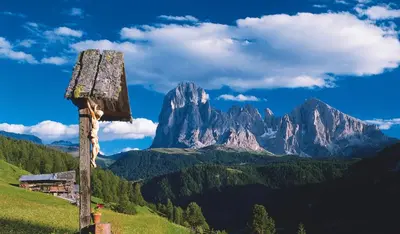a mountain in the distance with a sign in the foreground at SAN PIETRO DOLOMITI Small Budget Hotel in Ortisei