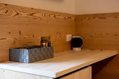 a counter in a room with a wooden wall at SAN PIETRO DOLOMITI Small Budget Hotel in Ortisei
