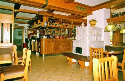 a restaurant with a table and chairs and a counter at Hotel Gran Mugon in Vigo di Fassa