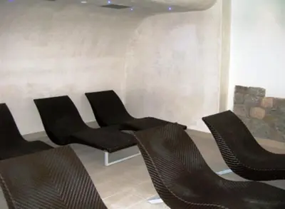 a group of chairs sitting in a room at Hotel Gran Mugon in Vigo di Fassa