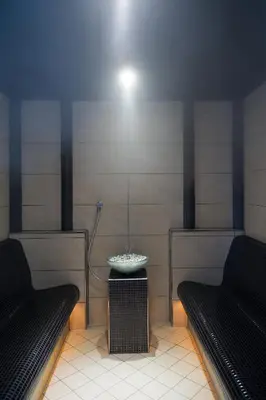 a room with two benches and a sink in a room at Hotel Gran Mugon in Vigo di Fassa