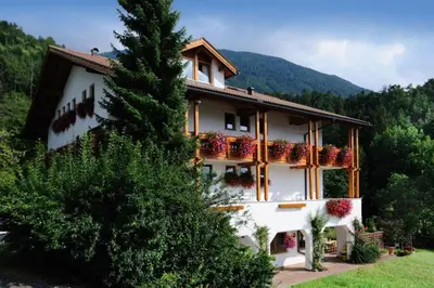 a house with flower boxes on the side of it at Hotel Mair Am Bach in Bressanone