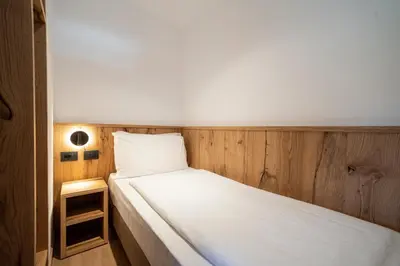 a small room with two beds and a small table at Residence Contrin in Canazei