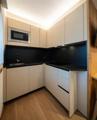 a kitchen with white cabinets and a microwave at Residence Contrin in Canazei