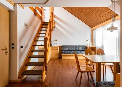 a staircase in a room with a table and a dining room at Residence Contrin in Canazei
