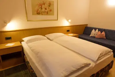 a bedroom with a large bed and a couch at Haus Aron in Brunico