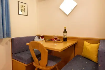 a table with two glasses of wine and a bottle at Haus Aron in Brunico