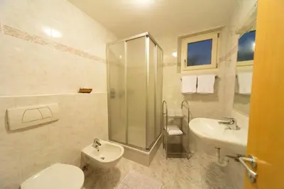 a bathroom with a toilet and a sink and a shower at Haus Aron in Brunico