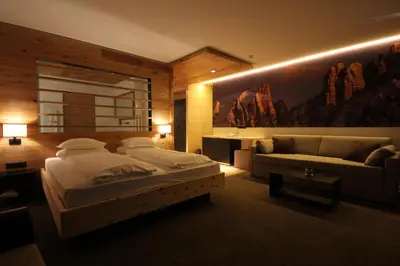 a bedroom with a large bed and a couch at Charme Hotel Friedrich in Nova Levante