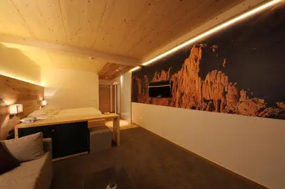 a room with a bed and a painting on the wall at Charme Hotel Friedrich in Nova Levante