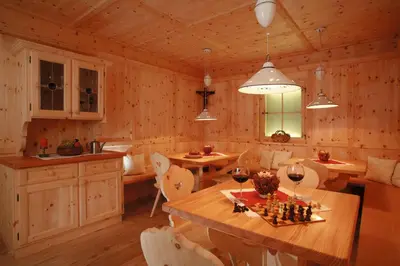 a kitchen and dining room with a table and chairs at Charme Hotel Friedrich in Nova Levante
