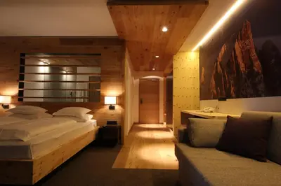 a bedroom with two beds and a couch at Charme Hotel Friedrich in Nova Levante