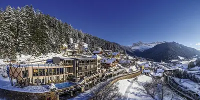 a resort in the mountains covered in snow at Charme Hotel Friedrich in Nova Levante