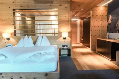 a bedroom with a white bed and a desk at Charme Hotel Friedrich in Nova Levante
