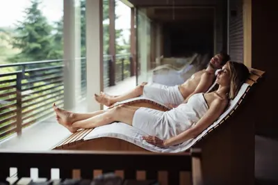 two people sitting in a hammock on a balcony at Giardino Marling in Merano